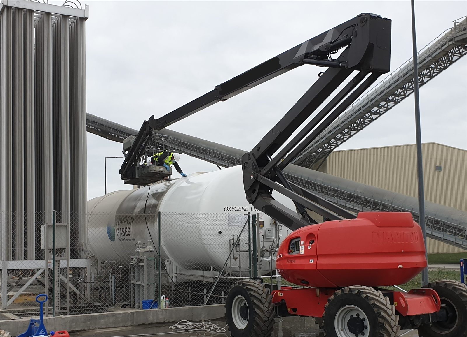 Équipe ELnet nettoyant une cuve d'oxygène sur un site industriel, accès en hauteur sécurisé